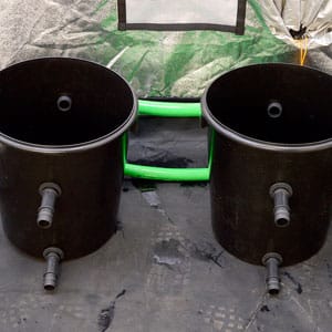 two buckets connect with green hose for hydroponic system